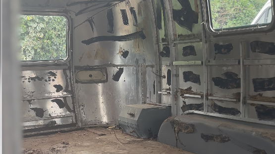 interno di un vintage trailer con la scocca dipinta con ampie pennellate di vernice nera