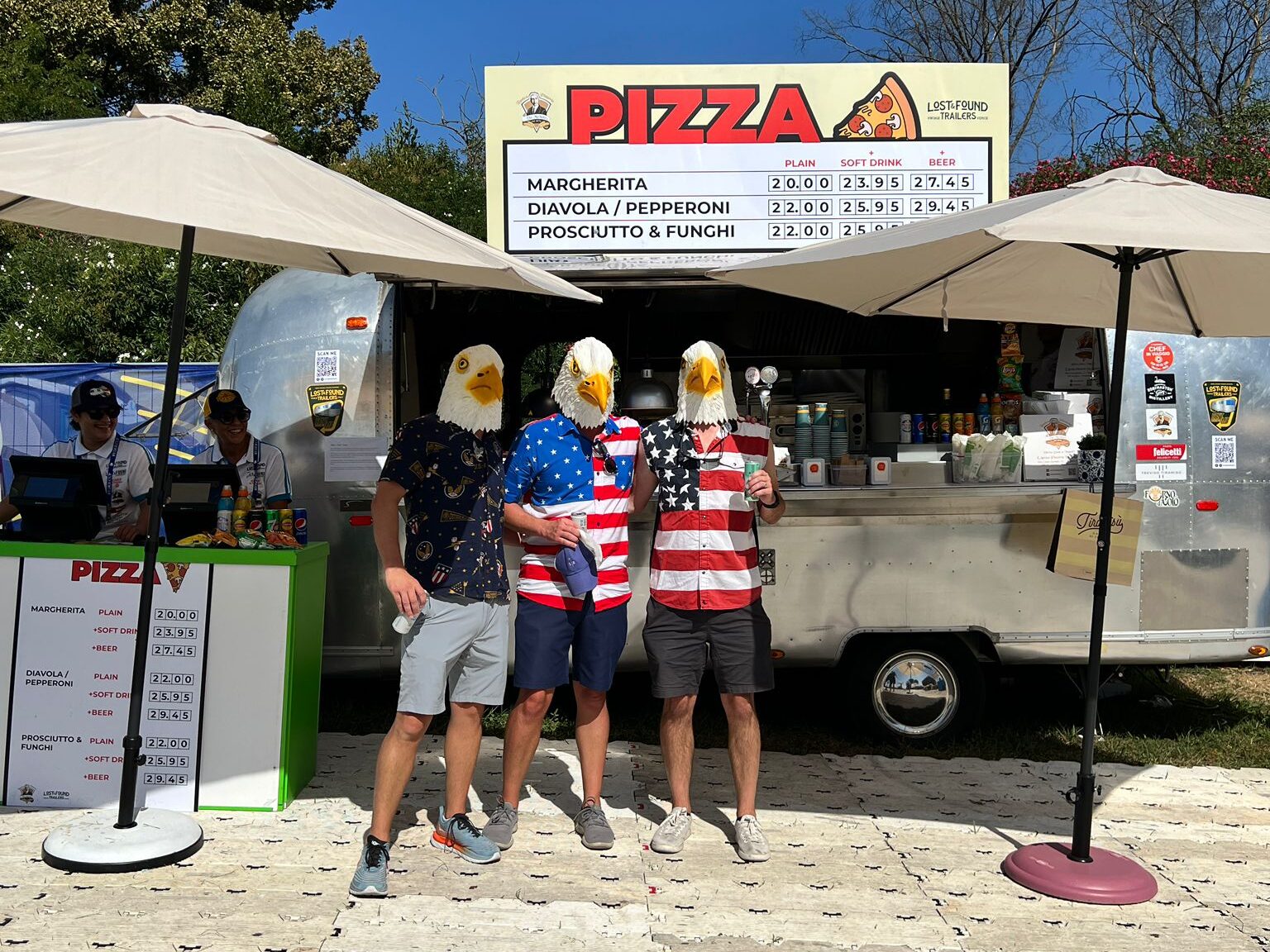 Tre uomini alla Ryder Cup vestiti con una testa d’aquila in plastica