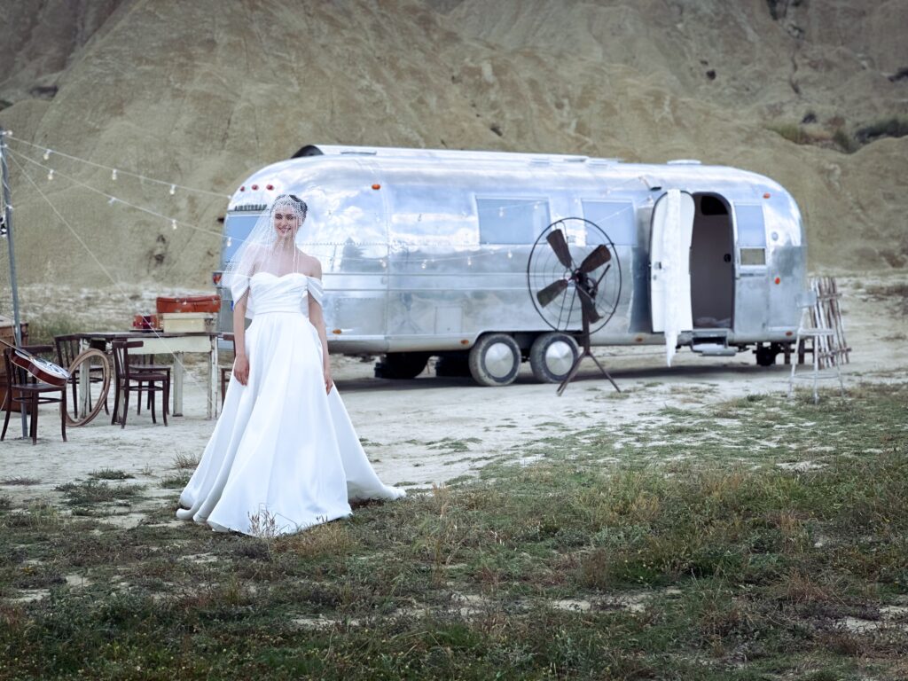 modella con indosso un abito da sposa e in background il nostro Airstream ambassador, cuore dello shooting per abiti da matrimonio in stile vintage gipsy