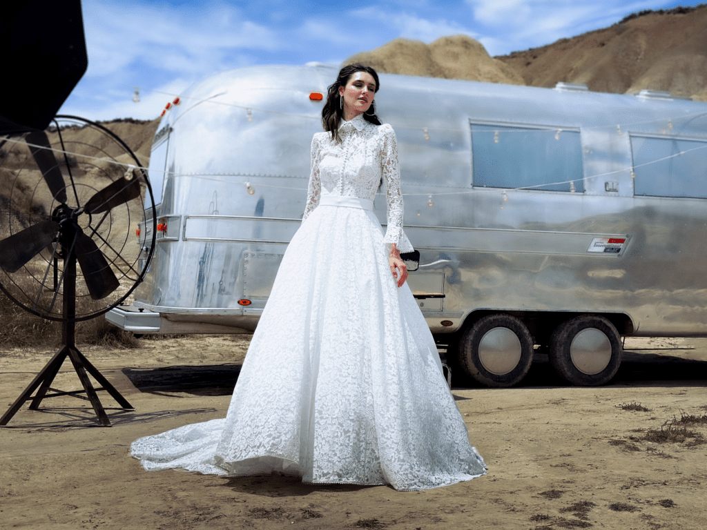 Modella dello shooting da matrimonio con indosso uno degli abiti da sposa della collezione e in background un vintage caravan americano Airstream